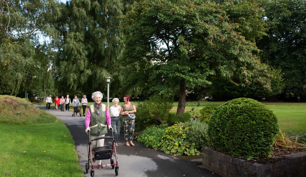 Residents walking in gardens at Connaught Court