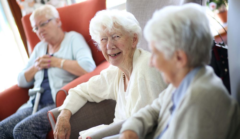 Residents relaxing on sofas in a care home lounge room
