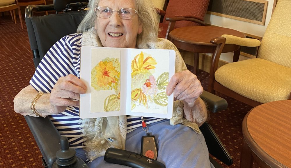 Resident Christine Goody, aged 85 at RMBI Care Co.Home Queen Elizabeth Court with her flowers painting